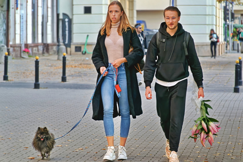 21 - Couple strolling down a pedestrian street in Kaunas, Lithuania, while walking a dog